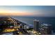 Aerial view of beachfront condos and city skyline at twilight, highlighting coastal living at 3000 N Atlantic Ave # 24, Daytona Beach, FL 32118