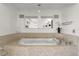 Luxurious bathtub with mosaic tile surround and elegant chandelier in the spacious bathroom at 3000 N Atlantic Ave # 24, Daytona Beach, FL 32118