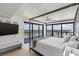 Bright bedroom with a four-poster bed and floor to ceiling windows with panoramic city views at 3000 N Atlantic Ave # 24, Daytona Beach, FL 32118