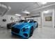 Well-lit garage featuring epoxy flooring and a blue convertible with transparent garage doors at 3000 N Atlantic Ave # 24, Daytona Beach, FL 32118