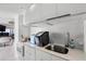 Modern kitchenette with sleek white cabinets and stainless steel sink, ideal for convenient food prep at 3000 N Atlantic Ave # 24, Daytona Beach, FL 32118