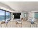 A great room with a large sofa, flat screen televisions, and floor-to-ceiling windows overlooking the ocean at 3000 N Atlantic Ave # 24, Daytona Beach, FL 32118