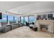 Spacious living room with comfortable seating, fireplace, and stunning ocean views from floor-to-ceiling windows at 3000 N Atlantic Ave # 24, Daytona Beach, FL 32118