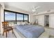 Cozy bedroom featuring plush bedding, modern ceiling fan, and expansive windows at 3000 N Atlantic Ave # 24, Daytona Beach, FL 32118