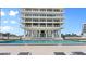 A beautiful outdoor swimming pool located in front of a tall condo with patio furniture for residents to enjoy at 3000 N Atlantic Ave # 24, Daytona Beach, FL 32118
