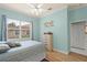 Light blue bedroom featuring a window and hardwood flooring at 3166 Kailani Ct, Ormond Beach, FL 32174