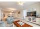 Open-concept living area featuring tile flooring, a large flat-screen TV, and adjacent dining area at 3315 S Atlantic Ave # 1106, Daytona Beach, FL 32118