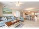 Comfortable living room featuring tile flooring, a ceiling fan, and coordinated furniture with a view into the dining area at 3315 S Atlantic Ave # 1106, Daytona Beach, FL 32118