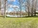 Scenic view of the lake, framed by bare trees and green grass at 3354 Hamlet Loop, Winter Park, FL 32792