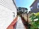 A walkway between two homes, featuring a decorative mulch garden with trees in the background on a sunny day at 3354 Hamlet Loop, Winter Park, FL 32792