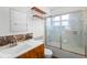 Well-lit bathroom with updated vanity, swan etched glass shower door and wall shelving for storage at 370 Charles Ave, Orange City, FL 32763
