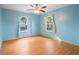 Light-filled bedroom with blue walls, a ceiling fan, and large windows overlooking the outdoors at 370 Charles Ave, Orange City, FL 32763