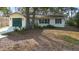 A well-maintained home featuring a lush front yard with mature trees, and a paved driveway leading to an attached garage at 370 Charles Ave, Orange City, FL 32763