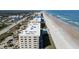 Aerial view of a condo building on the beach with a pool, showing its premium beachfront location and parking area at 4631 S Atlantic S Ave # 8201, Ponce Inlet, FL 32127