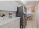 Modern kitchen with stainless steel refrigerator, white cabinetry, and a view into the breakfast nook for easy mornings at 4631 S Atlantic S Ave # 8201, Ponce Inlet, FL 32127