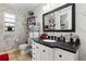 The bathroom has a black granite countertop, a sink, a black framed mirror and an abundance of storage at 480 Columbus Ave, Orange City, FL 32763
