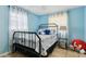Cozy bedroom with blue walls, tile flooring, and a comfortable bed setup with natural light at 480 Columbus Ave, Orange City, FL 32763