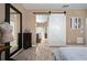 Bedroom with wood-look flooring, barn door access to the bathroom and neutral toned walls at 5065 Nw 35Th Pl, Ocala, FL 34482
