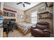 Cozy bedroom with a ceiling fan, a leather chair, and wood-look tile flooring at 5065 Nw 35Th Pl, Ocala, FL 34482