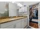 Bathroom featuring double sinks with granite counters, ample storage, and a walk-in closet at 562 Landshark Blvd, Daytona Beach, FL 32124
