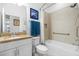 Bathroom featuring granite counters, tile shower and tub combination with shower head, and blue accent towels at 562 Landshark Blvd, Daytona Beach, FL 32124