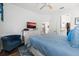Bedroom featuring a blue comforter, a dresser with a TV, and an accent chair with dark hardwood floors at 562 Landshark Blvd, Daytona Beach, FL 32124