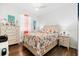 Bright bedroom with wood floors and a decorative coral reef themed bedspread for a cheerful beach vibe at 562 Landshark Blvd, Daytona Beach, FL 32124