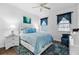 Bedroom featuring a queen-sized bed with a blue comforter and white nightstands, plus stylish rug and decor at 562 Landshark Blvd, Daytona Beach, FL 32124