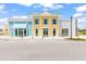 Charming two-story commercial building with a vibrant yellow facade and blue accents at 562 Landshark Blvd, Daytona Beach, FL 32124