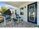 Charming front porch with blue chairs, a table, and a blue wreath on the front door at 562 Landshark Blvd, Daytona Beach, FL 32124