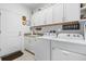 Laundry room featuring white cabinets, granite counters, a sink, and a washing machine and dryer at 562 Landshark Blvd, Daytona Beach, FL 32124