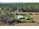 An aerial shot of the home with a lush tree line, and a metal roof at 5717 Us Highway 17, De Leon Springs, FL 32130