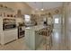 Bright, well-organized kitchen with a center island, stainless steel appliances, open shelving, and tiled floors at 5717 Us Highway 17, De Leon Springs, FL 32130