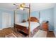 Primary bedroom featuring a four-poster bed, wood floors, and a ceiling fan at 600 N Boundary Ave # 115D, Deland, FL 32720