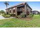 Two-story condo building with wood siding, a shingled roof, balconies, and well-maintained landscaping at 600 N Boundary Ave # 115D, Deland, FL 32720