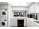 Bright kitchen features white cabinets, modern appliances, laundry and a view into the living room at 600 N Boundary Ave # 115D, Deland, FL 32720