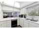 Bright kitchen features white cabinets, modern appliances, and a view into the living room at 600 N Boundary Ave # 115D, Deland, FL 32720