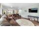 Bright living room leading to the kitchen, featuring leather furniture and a mounted flatscreen television at 600 N Boundary Ave # 115D, Deland, FL 32720