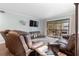 Inviting living room with brown leather furniture and sliding door to the balcony, and a flatscreen television at 600 N Boundary Ave # 115D, Deland, FL 32720