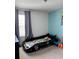 This fun themed-bedroom features a custom car bed, grey curtains, and carpeted floors at 7024 Lanier Falls Rd, Deland, FL 32724