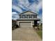 Charming two-story home with a gray exterior, blue shutters, landscaped yard, and brick driveway at 7024 Lanier Falls Rd, Deland, FL 32724
