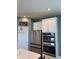 This kitchen features stainless steel appliances, white cabinets, and stylish pendant lighting at 7024 Lanier Falls Rd, Deland, FL 32724
