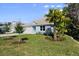 This light blue home offers a manicured lawn with young trees and palm, providing a serene setting at 72 Aurora Ave, Ponce Inlet, FL 32127