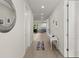 Bright hallway with white walls, wood floors, a console table and a peek into the modern kitchen at 72 Aurora Ave, Ponce Inlet, FL 32127