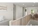 Hallway with modern wood railing, artwork, neutral walls, and plush seating at 72 Aurora Ave, Ponce Inlet, FL 32127