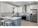 Bright kitchen featuring white upper and blue lower cabinets, stainless steel appliances, and a central island with seating at 72 Aurora Ave, Ponce Inlet, FL 32127