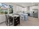 Eat in kitchen with white cabinets, stainless appliances and large windows at 72 Aurora Ave, Ponce Inlet, FL 32127