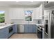 Modern kitchen with white and blue cabinets, stainless steel appliances, and patterned backsplash at 72 Aurora Ave, Ponce Inlet, FL 32127