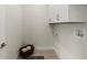 A neat laundry room features overhead cabinets, a laundry basket, and laundry hookups at 72 Aurora Ave, Ponce Inlet, FL 32127