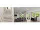 Open-concept living and dining area with hardwood floors, contemporary furnishings, and natural light through large windows at 72 Aurora Ave, Ponce Inlet, FL 32127